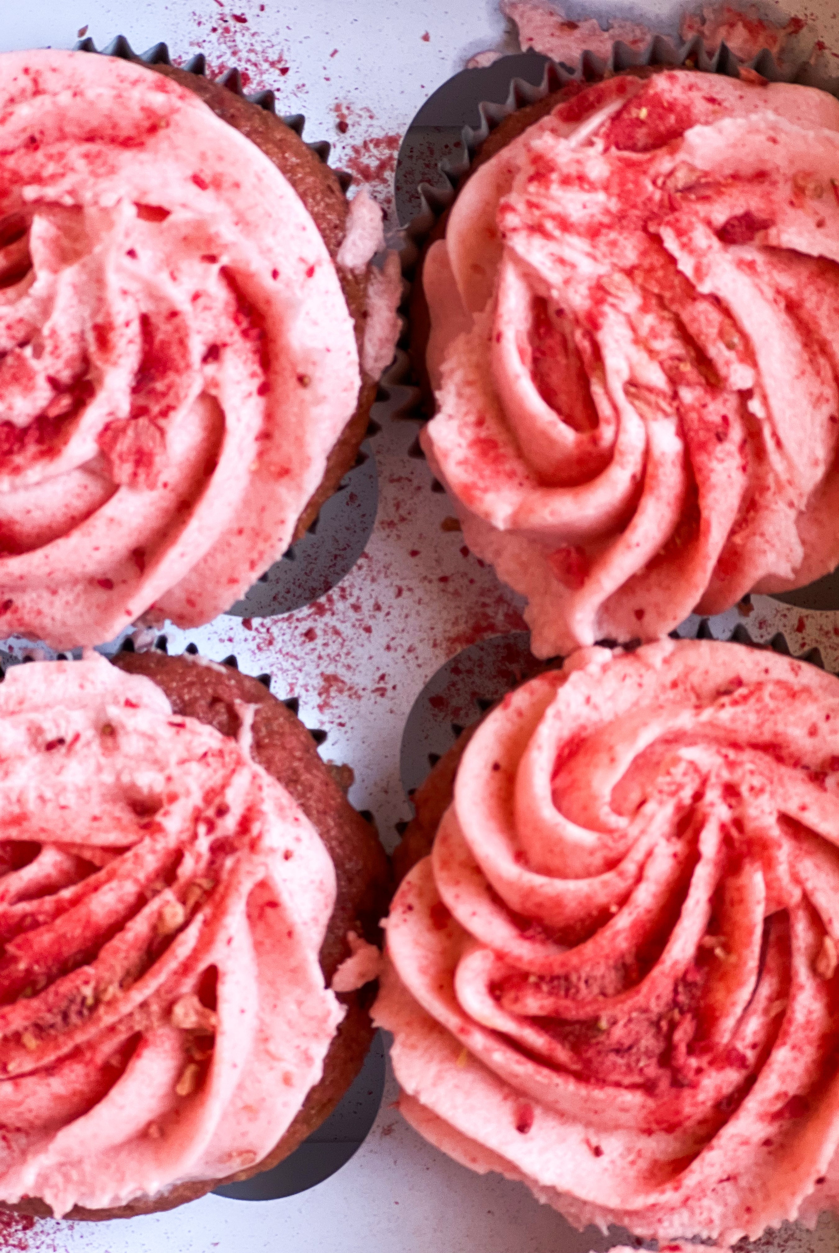 four pink cupcakes