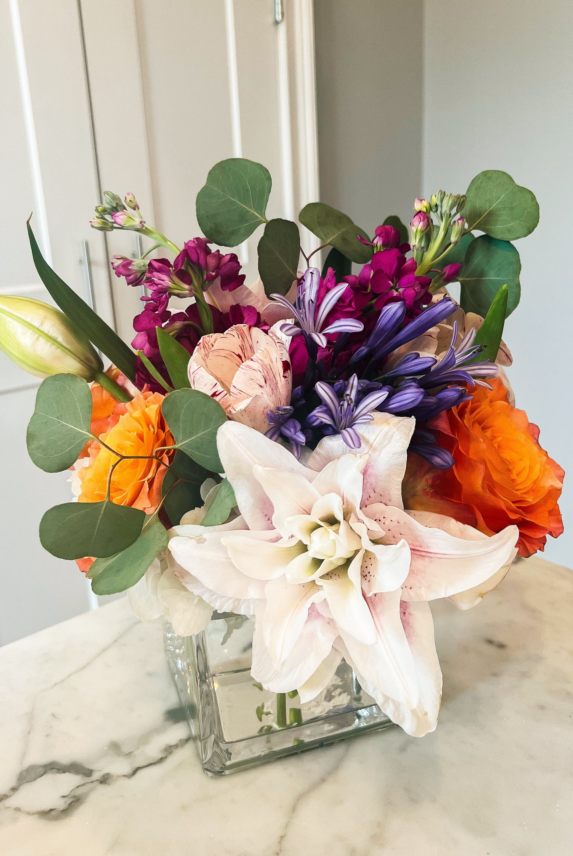 Colorful flower arrangement in a square clear vase