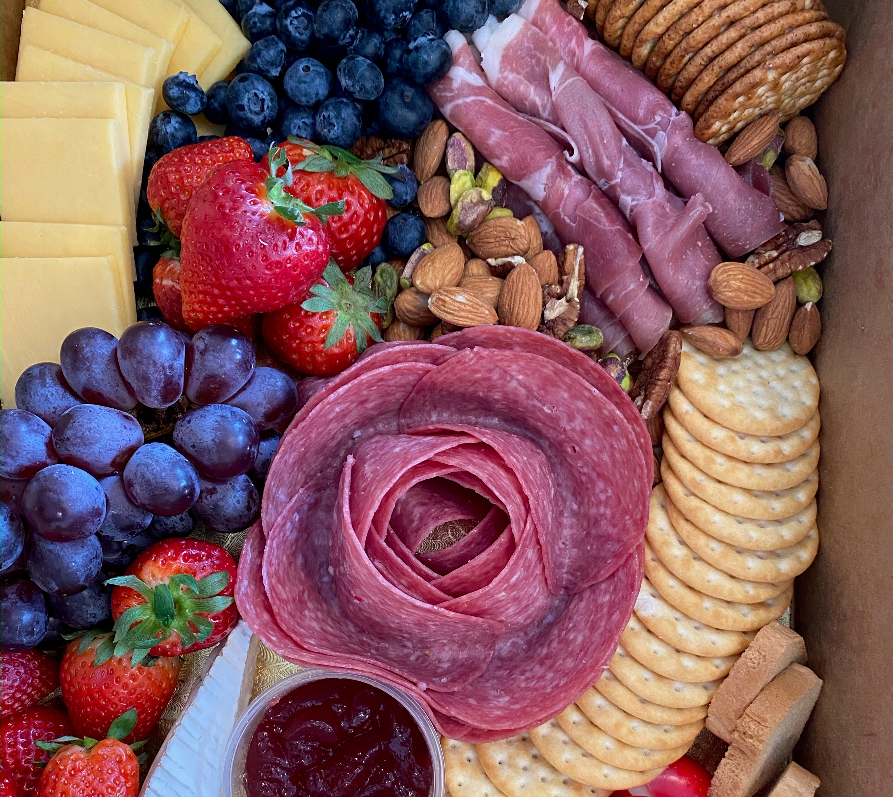 Charcuterie board with crackers, cheese, meats, nuts and fruits