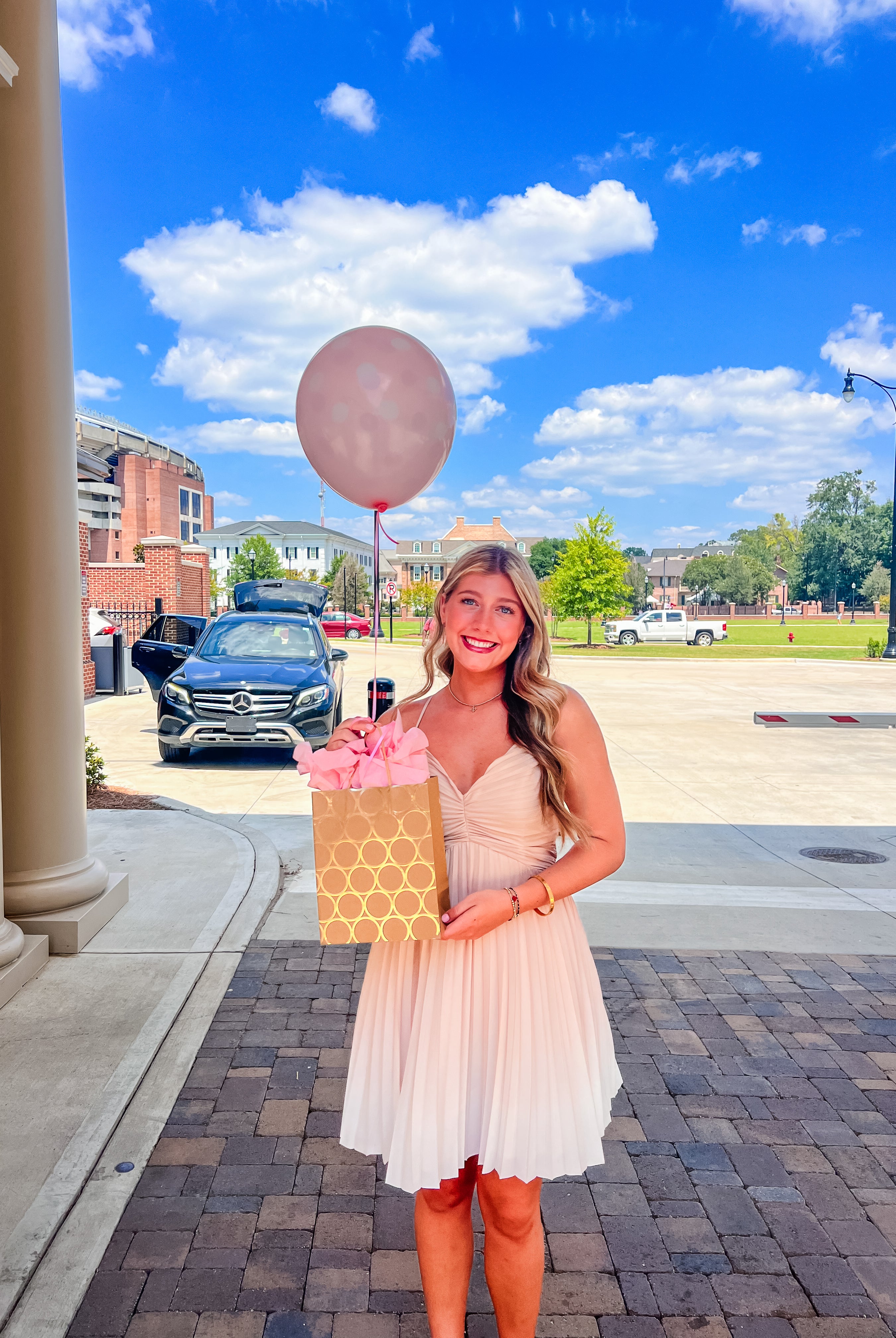 Girl holding gift bag with a pink balloon at the University of Alabama