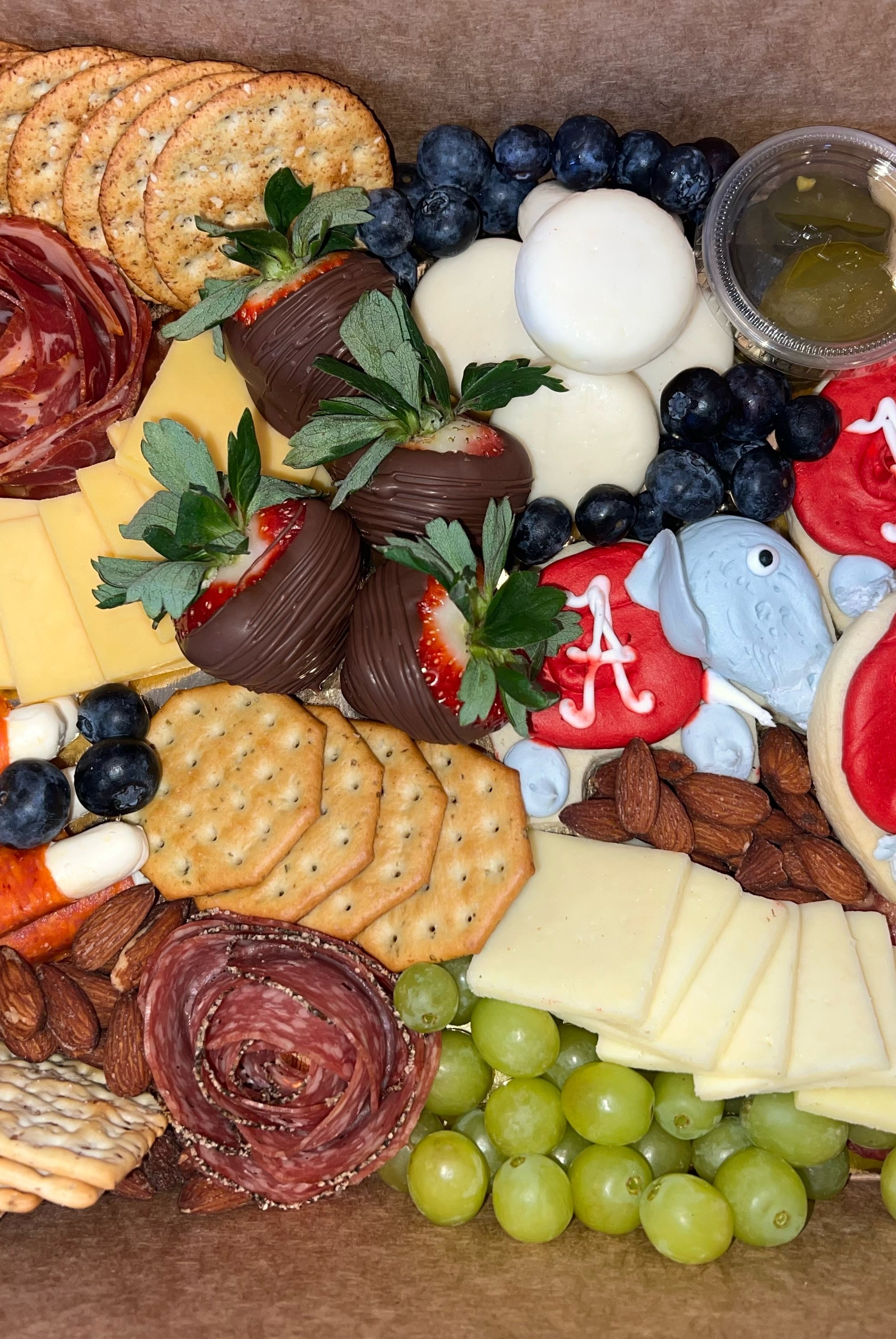 Alabama charcuterie board prepared for delivery with crackers, fruits, cheese, cookies