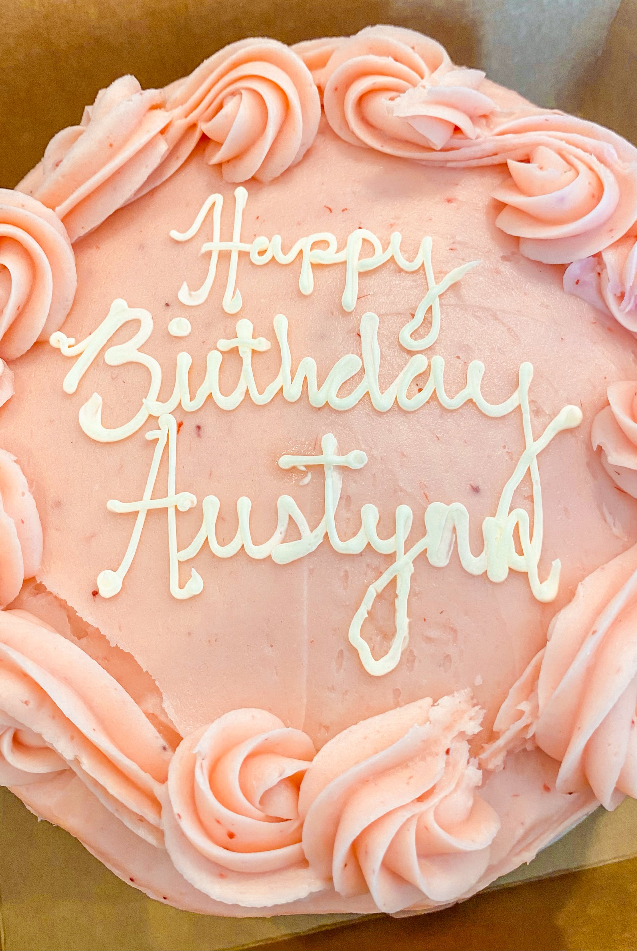 Cake with pink icing that says "Happy birthday Austin!"