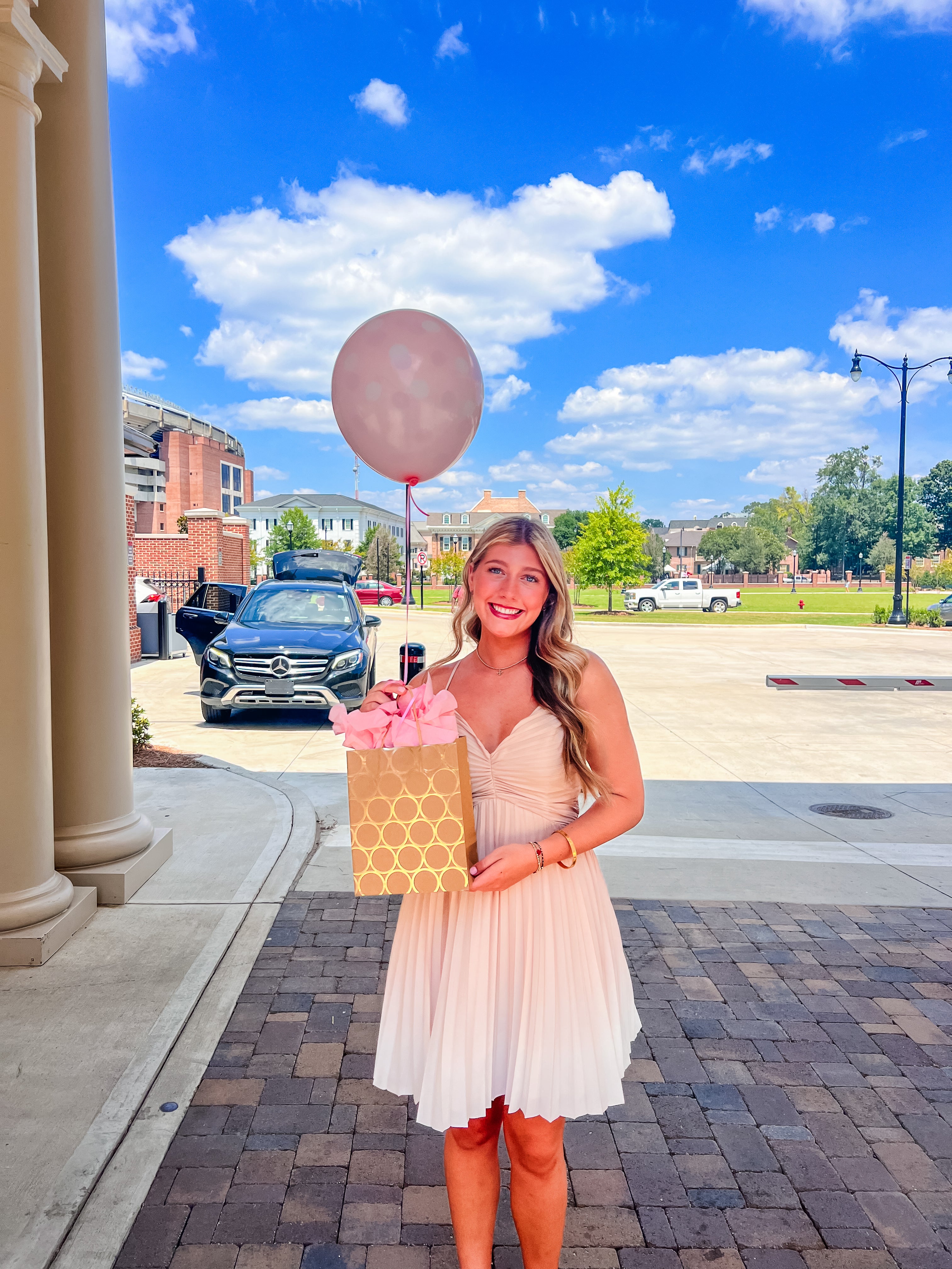 Girl holding gift bag with a pink balloon at the University of Alabama